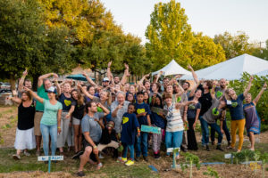 Large group of volunteers celebrating at the Green Heart Project's annual harvest dinner supporting Farms