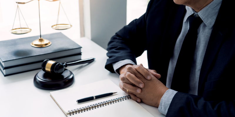 A personal injury attorney at a desk with legal books, a gavel, and a notepad,