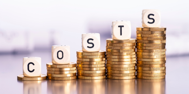 Stacked coins spelling "Costs" illustrate the financial considerations in personal injury settlements, explaining why most
