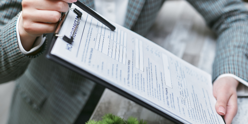 Close-up of hands holding a clipboard with legal documents, representing Christmas Injury Lawyers assisting motorcycle