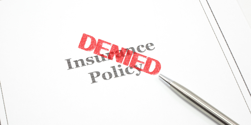 Document showing an insurance policy with the word "DENIED" stamped in red, symbolizing challenges maritime