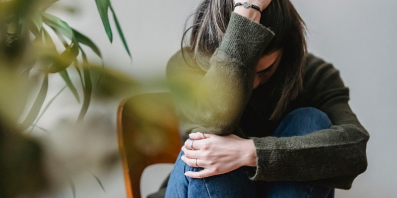 Woman with her head in her hands, conveying grief and distress, representing the emotional toll