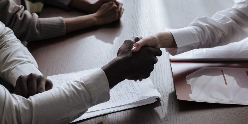 Close-up of a handshake between a lawyer and client, symbolizing legal representation and support after