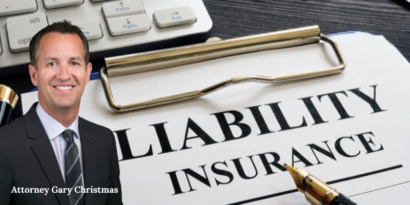 Attorney Gary Christmas next to a document labeled "Liability Insurance," with a keyboard and pen,